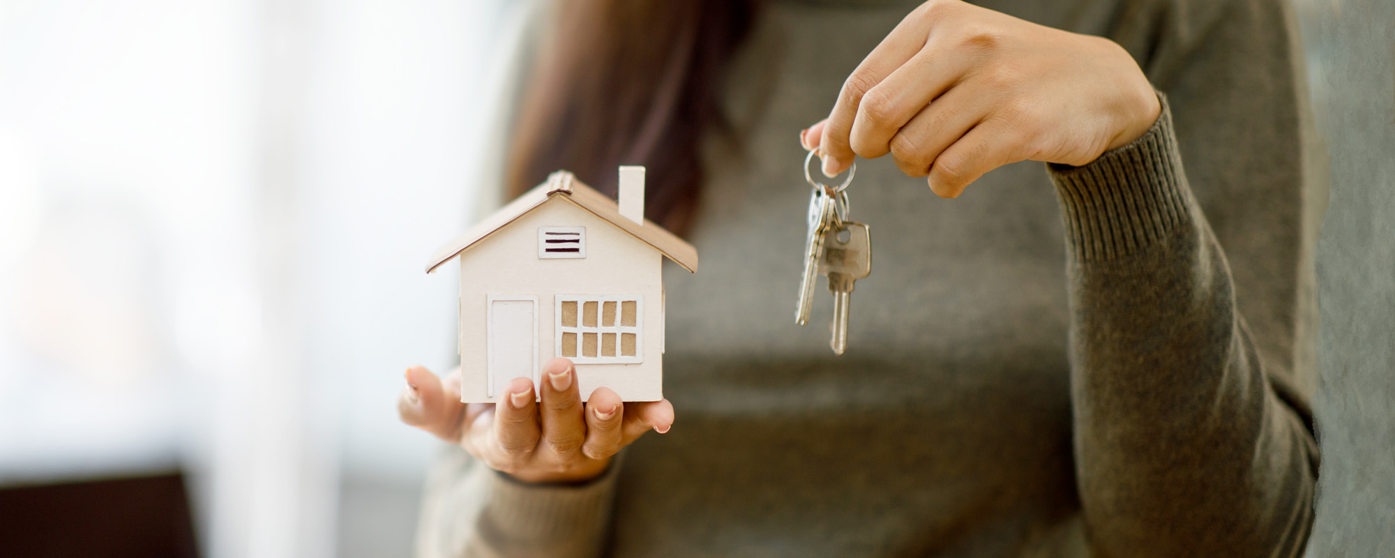 woman hands holding home model mortgage
