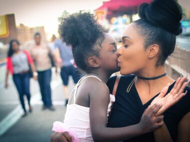 mother kissing daughter