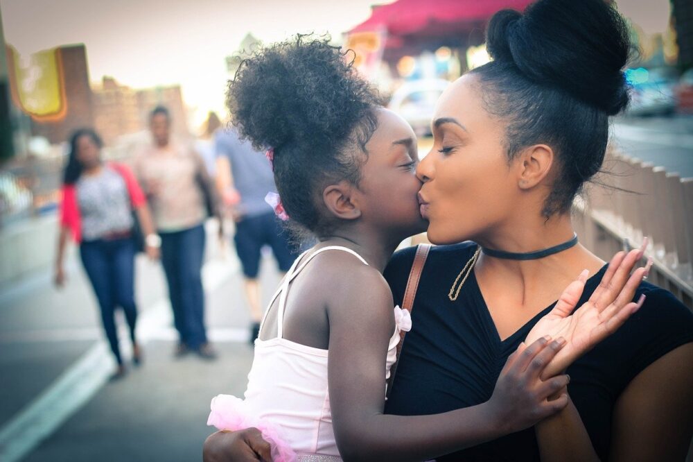 mother kissing daughter