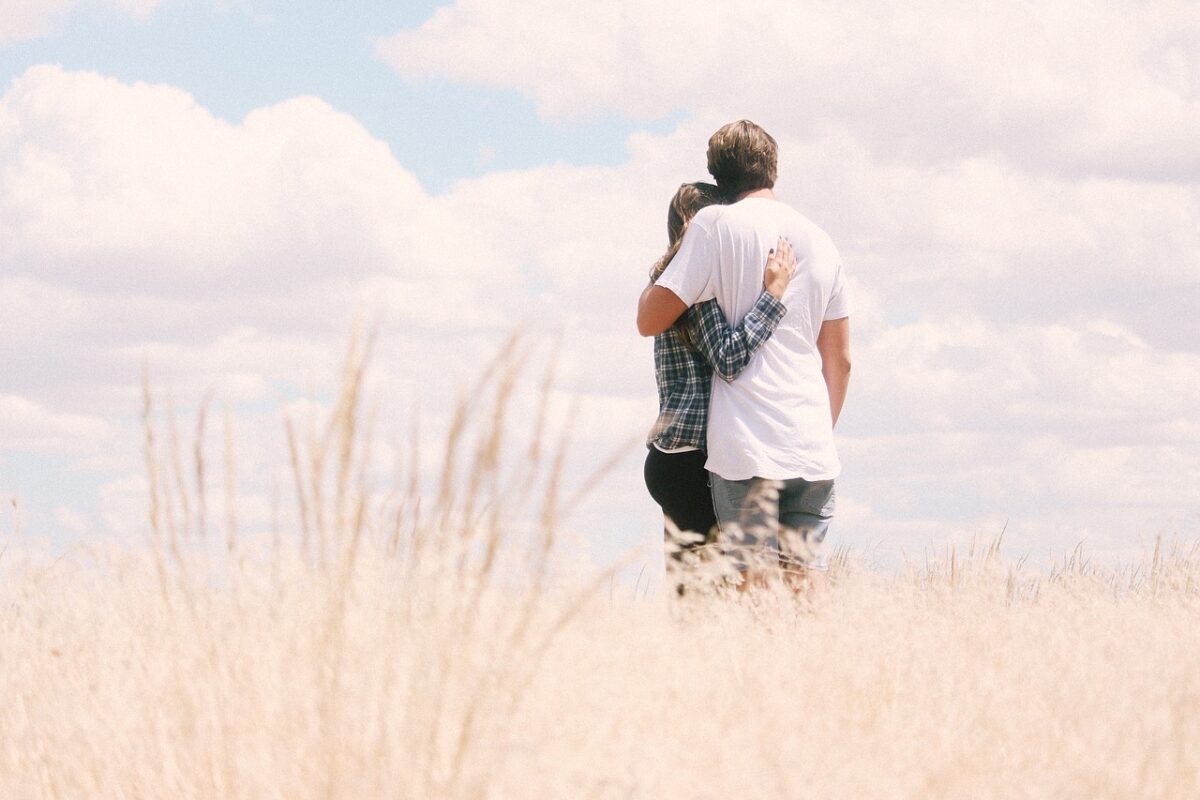 couple hugging field